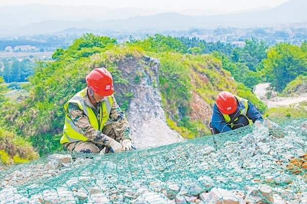 5月18日，武穴市觀山寨礦區(qū)北泉凹礦段山體修復(fù)現(xiàn)場，中南電力設(shè)計(jì)院有限公司施工人員正在進(jìn)行山體護(hù)網(wǎng)綁扎。